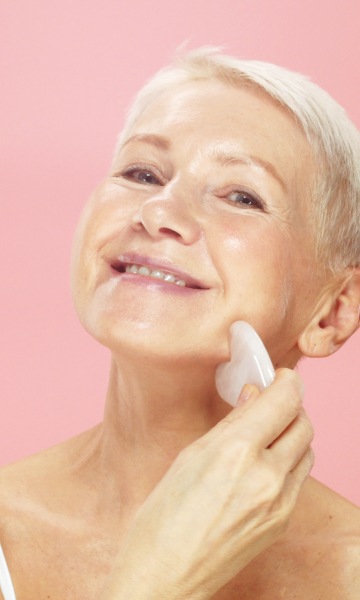 Old woman applying her adaptative skincare routine containing peptides